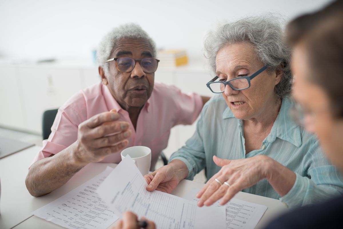 Elderly couple reading application | Stairlift Guru Elderly couple reading through a grant application together at home