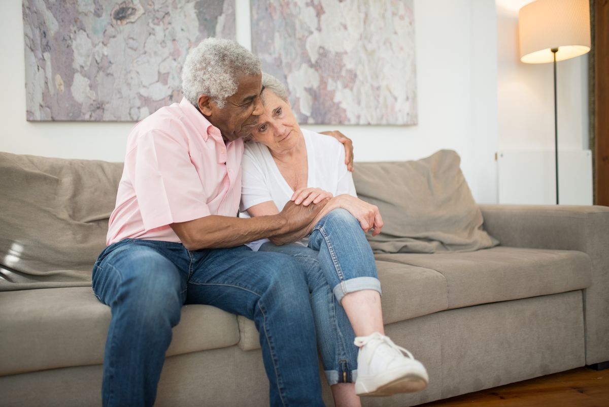 Elderly couple relaxing together on the sofa at home