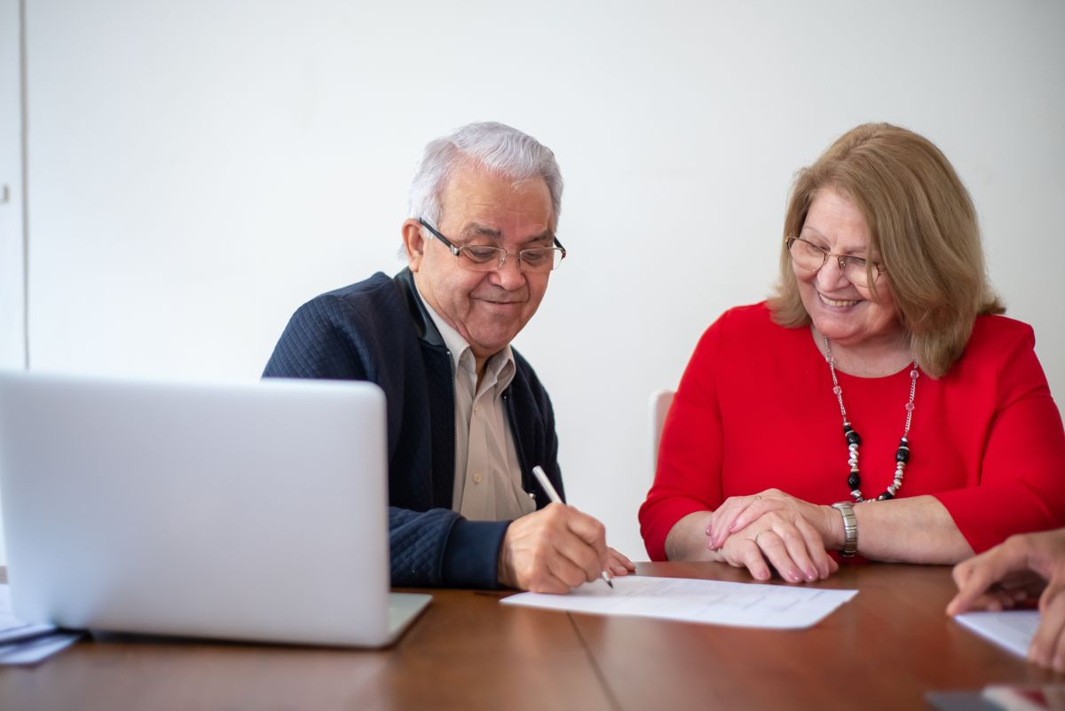 Senior couple comparing quotes and documents at a desk