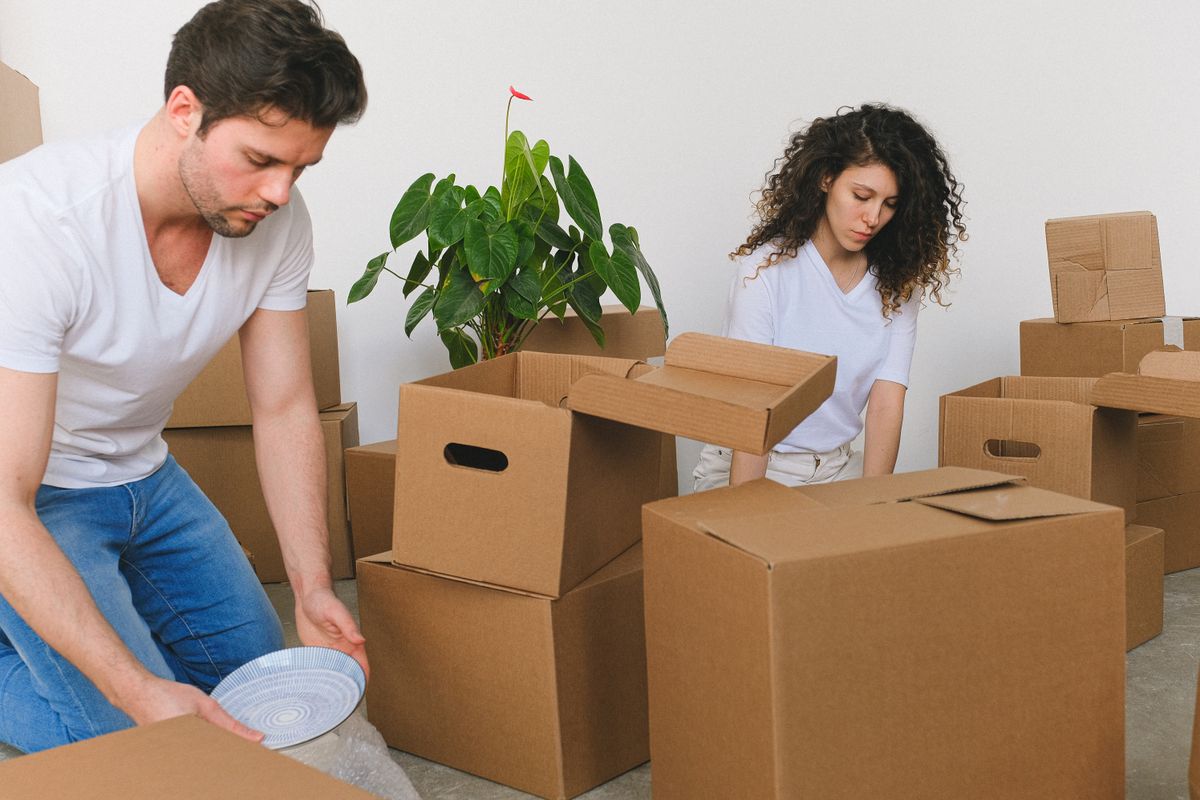 A couple packing boxes to move house