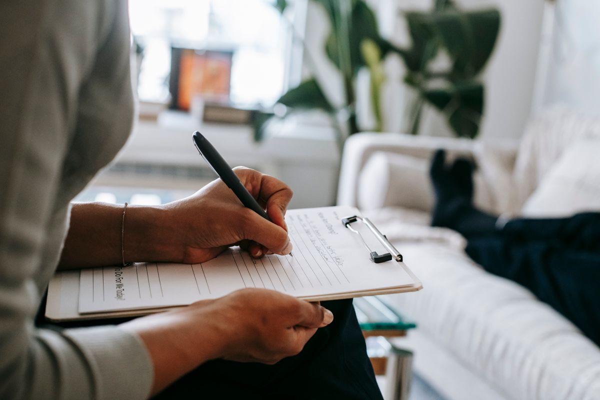 A healthcare worker writing on a clipboard A healthcare worker writing on a clipboard