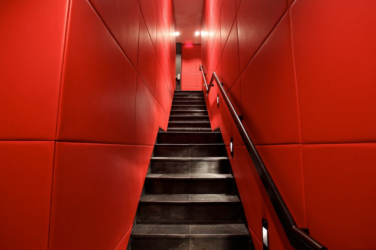 A narrow staircase in a red-walled interior