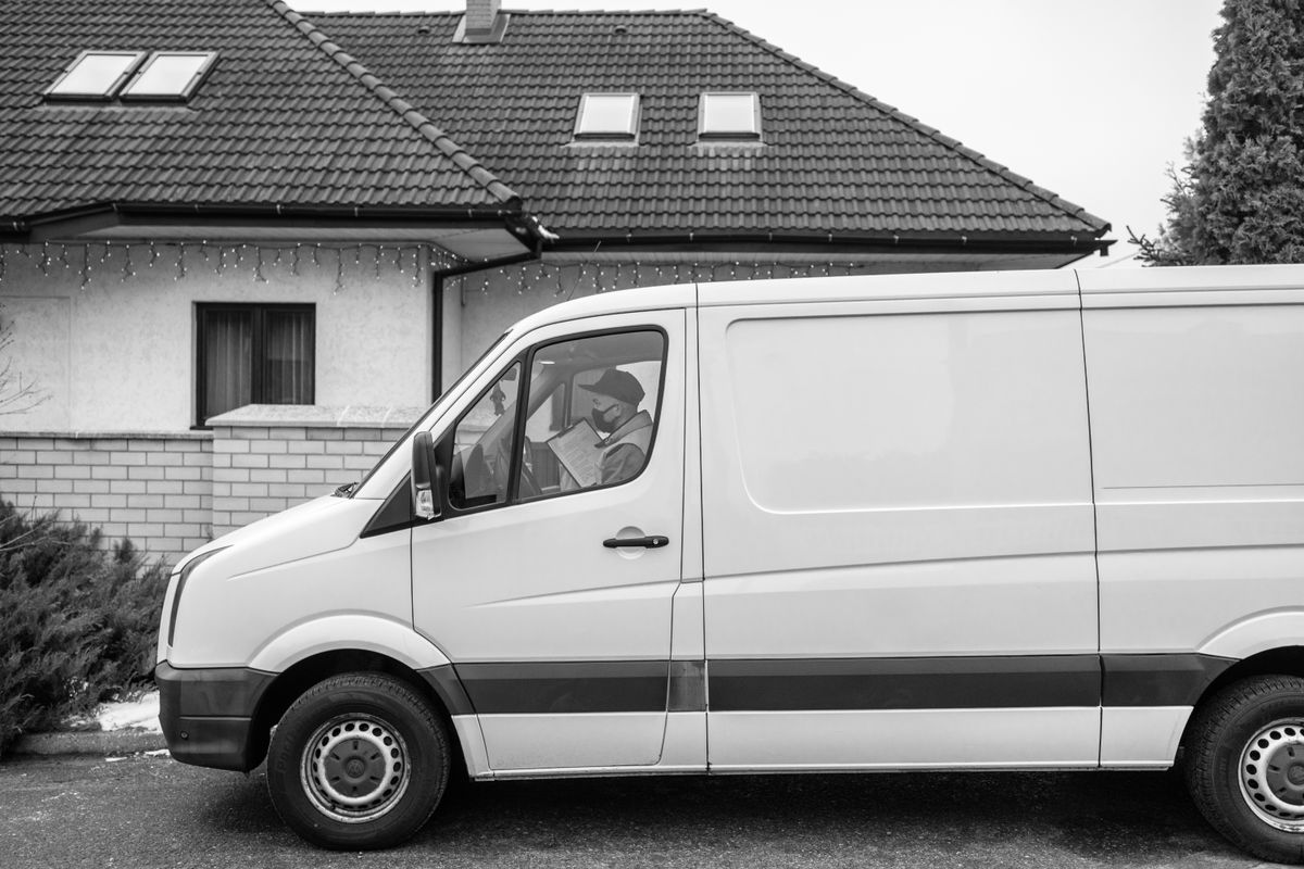 A white delivery van outside a house A white delivery van outside a house