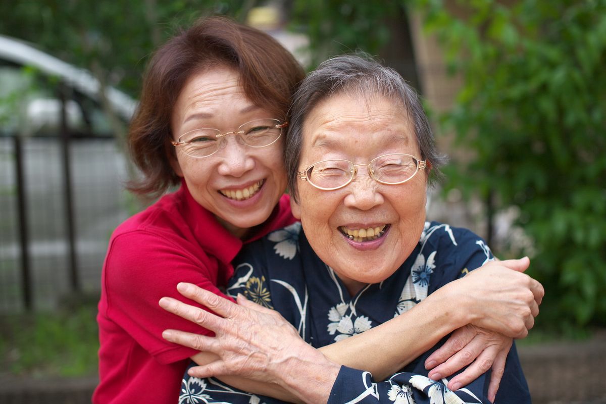 An adult daughter hugging her elderly mother An adult daughter hugging her elderly mother