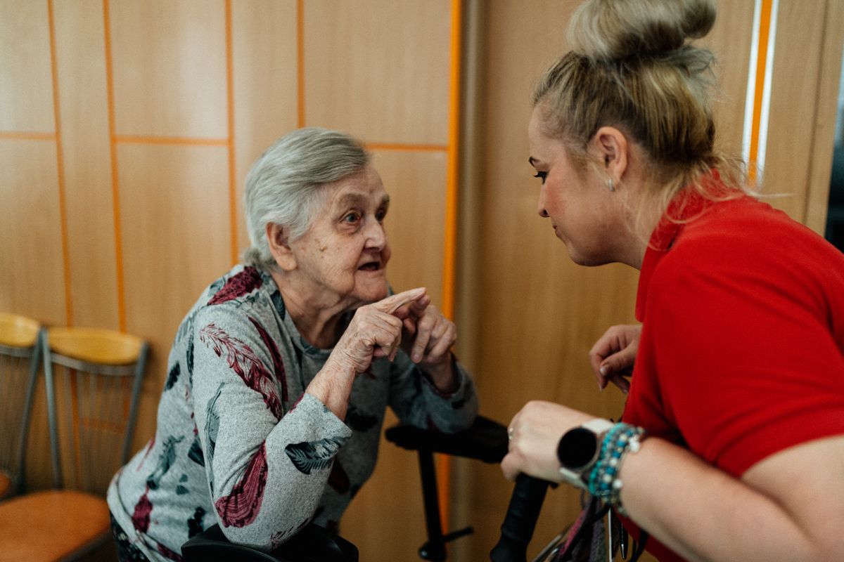 A care worker helping an older woman use a walking frame A care worker helping an older woman use a walking frame