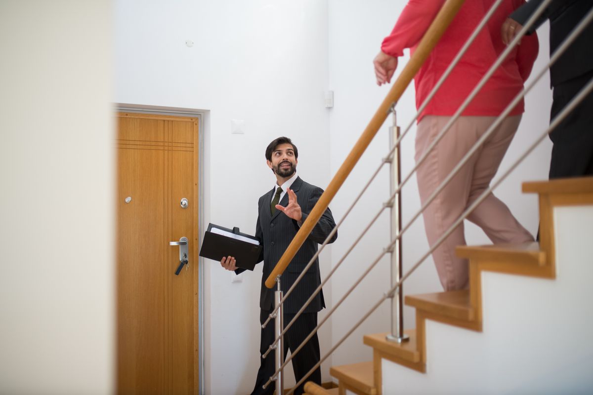 An estate agent showing a house with a staircase