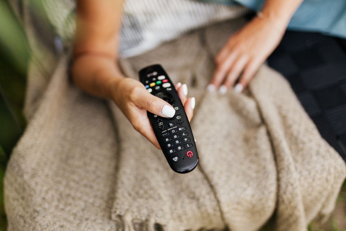 A hand holding a remote control A hand holding a remote control