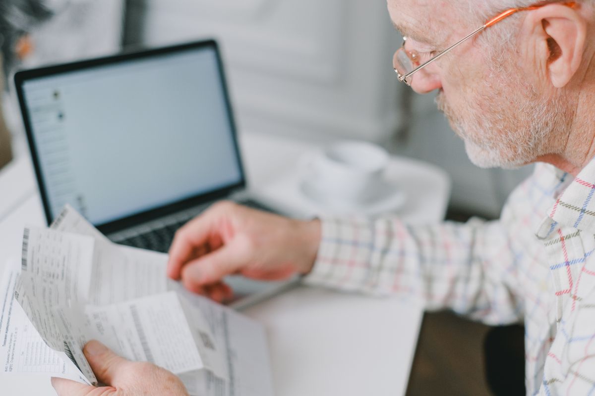 An older man going through household bills An older man going through household bills