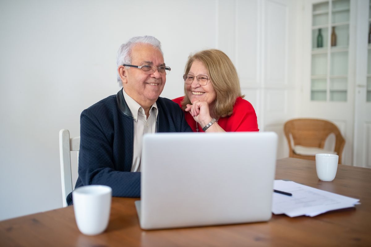 An older man reading figures on a laptop