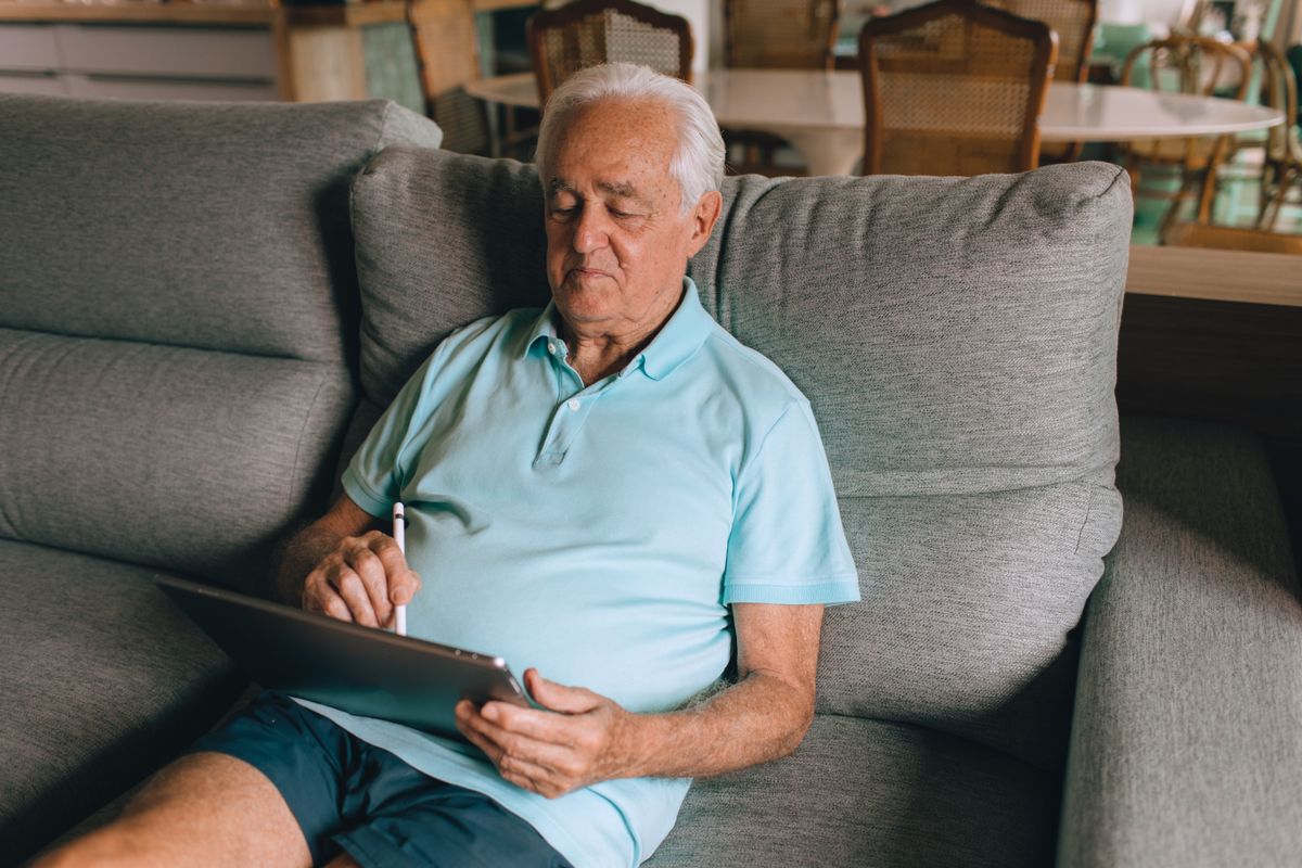 An older man using a tablet computer at home An older man using a tablet computer at home