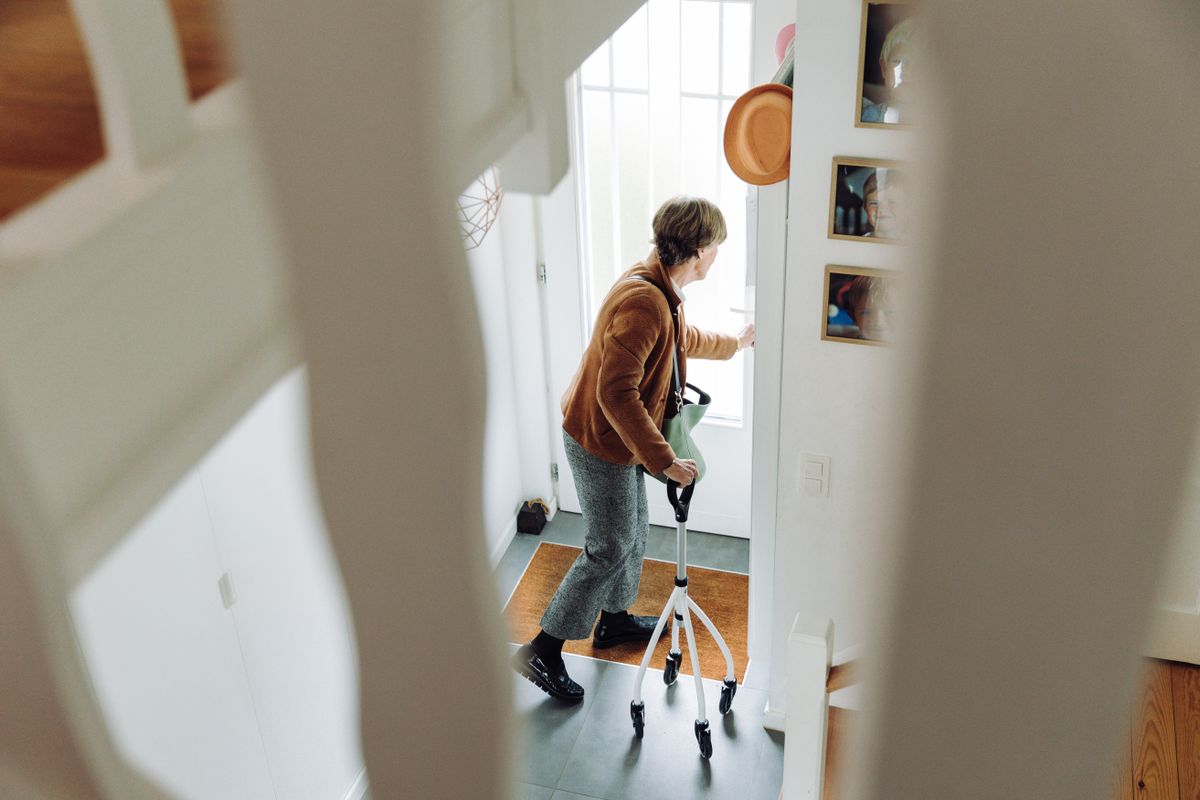An older person using a walking frame at home An older person using a walking frame at home