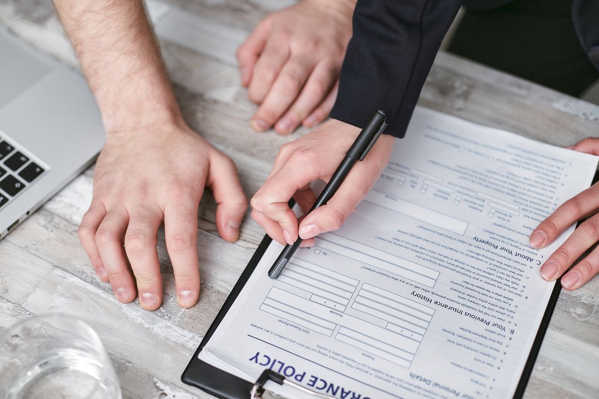 Signing an insurance policy document Signing an insurance policy document