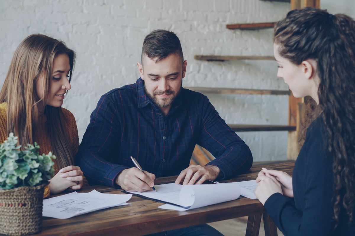 Signing property paperwork at a table