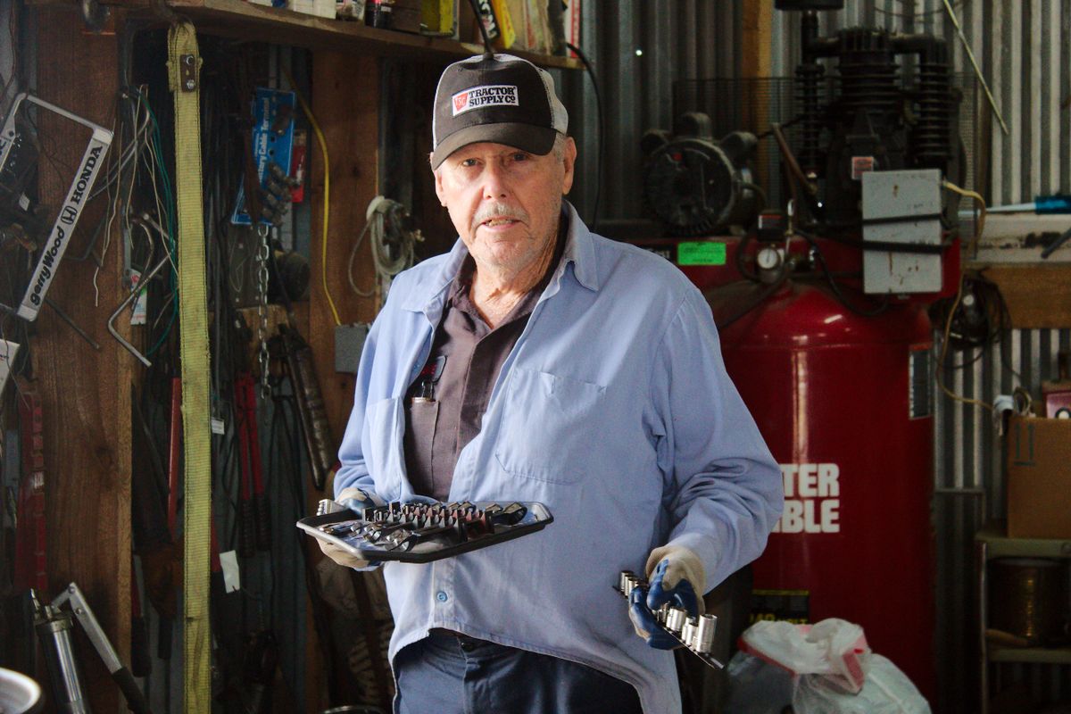 A tradesman holding tools in his workshop A tradesman holding tools in his workshop