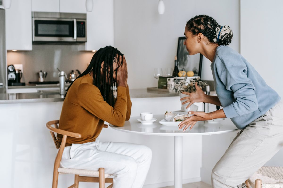 Two people talking at a kitchen table Two people talking at a kitchen table
