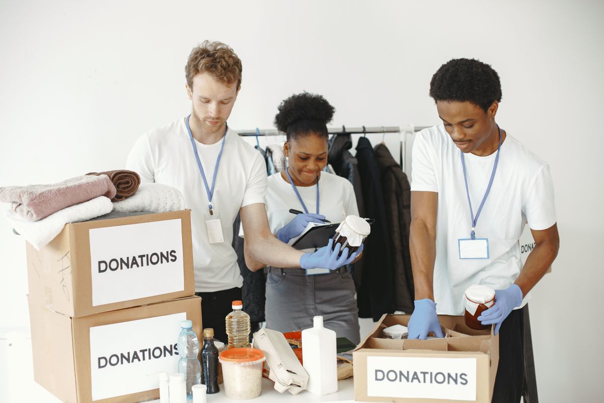 Volunteers with charity donation boxes Volunteers with charity donation boxes