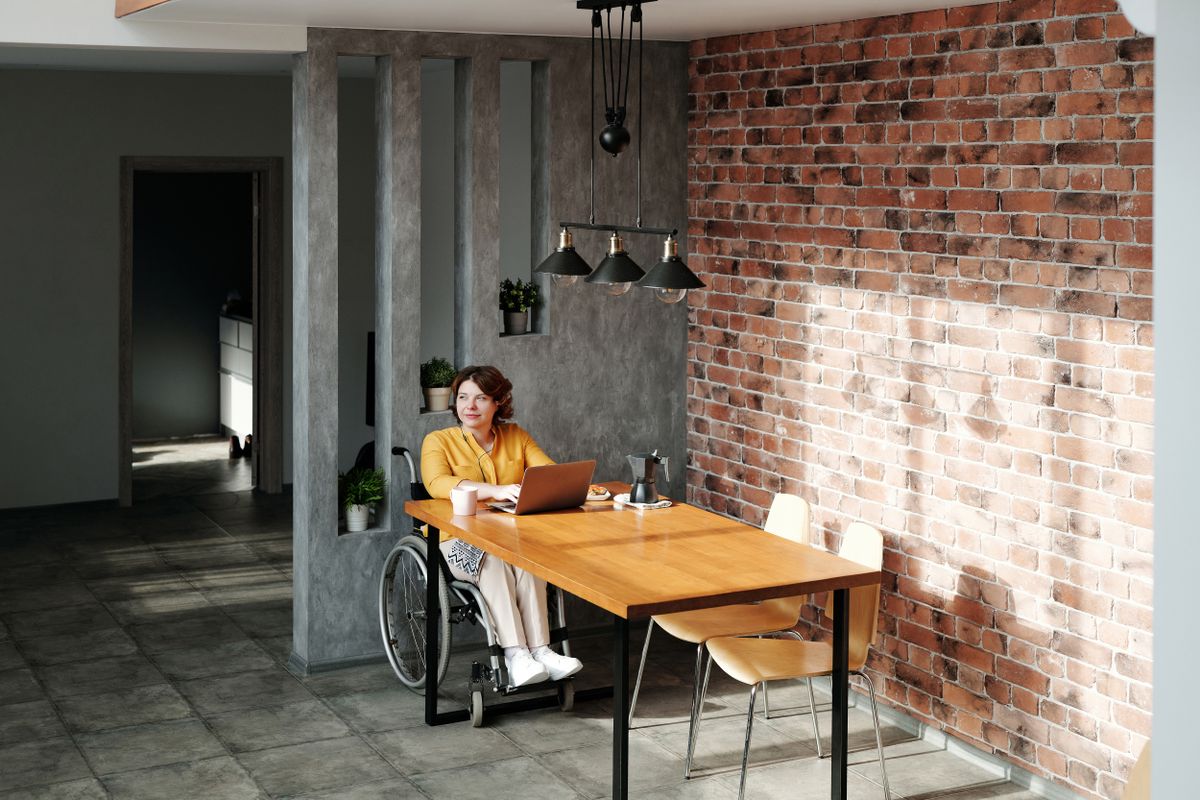 A wheelchair user sitting at a table at home A wheelchair user sitting at a table at home