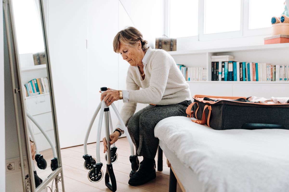 A woman with a wheelchair beside her bed at home A woman with a wheelchair beside her bed at home