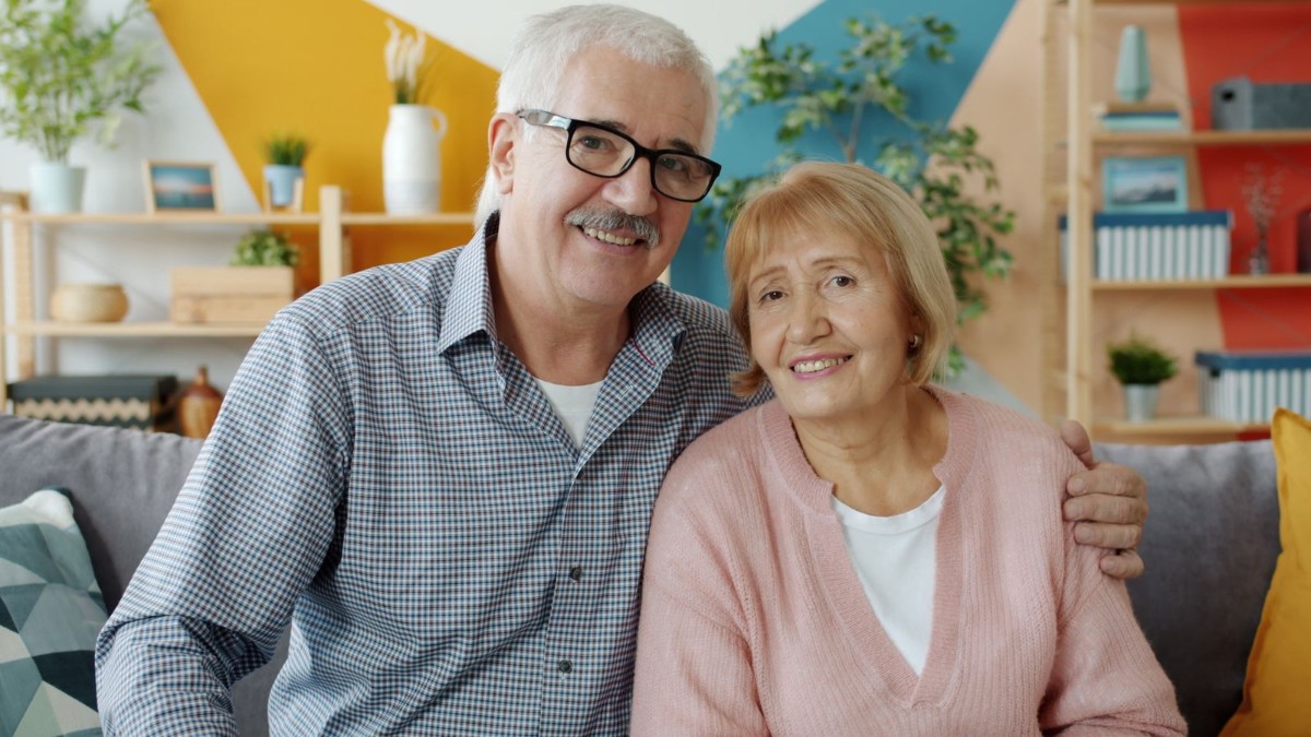 An older couple relaxing together in the living room of their home