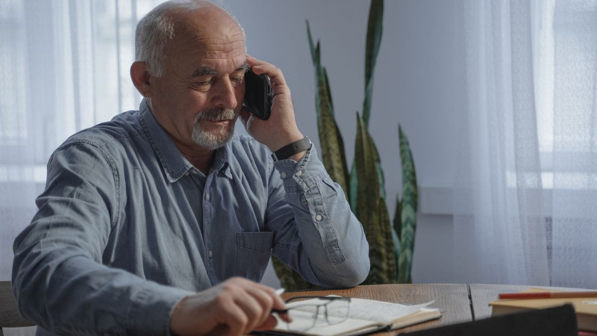 An older person at home using a landline telephone