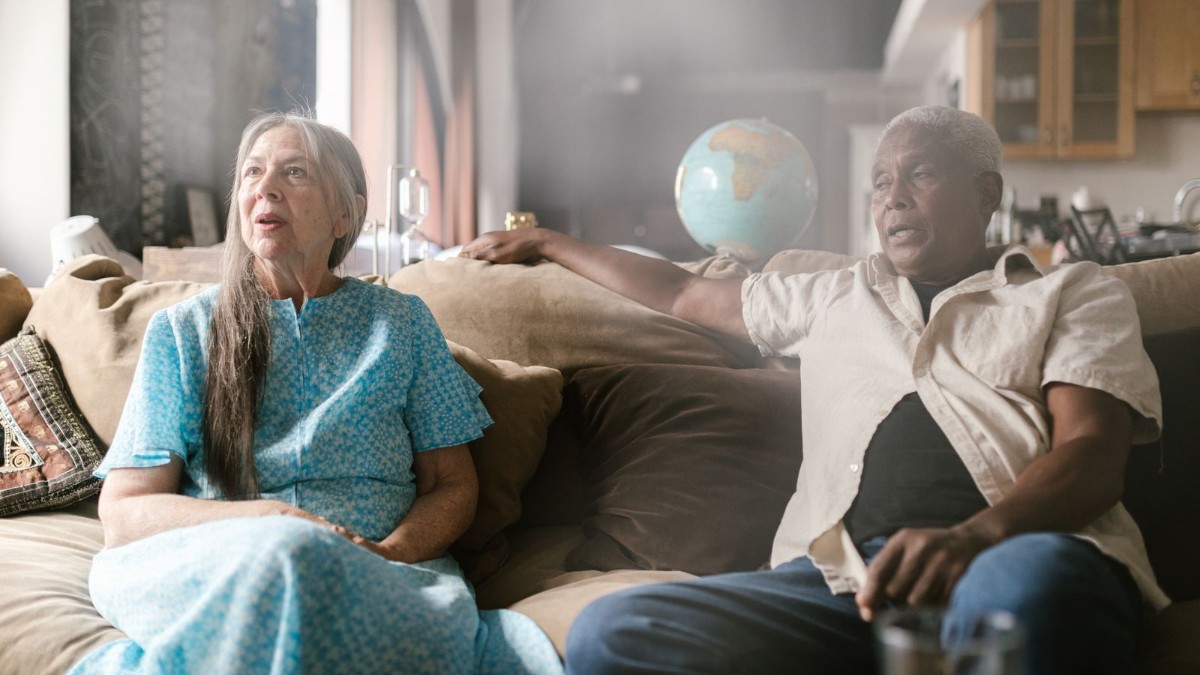 Older couple at home An older couple sitting together on a sofa at home