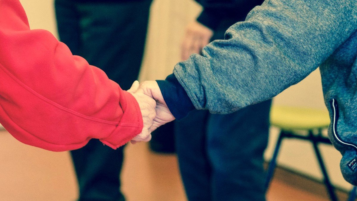 Supporting an older person to stay independent at home An older person's hands held in support at home